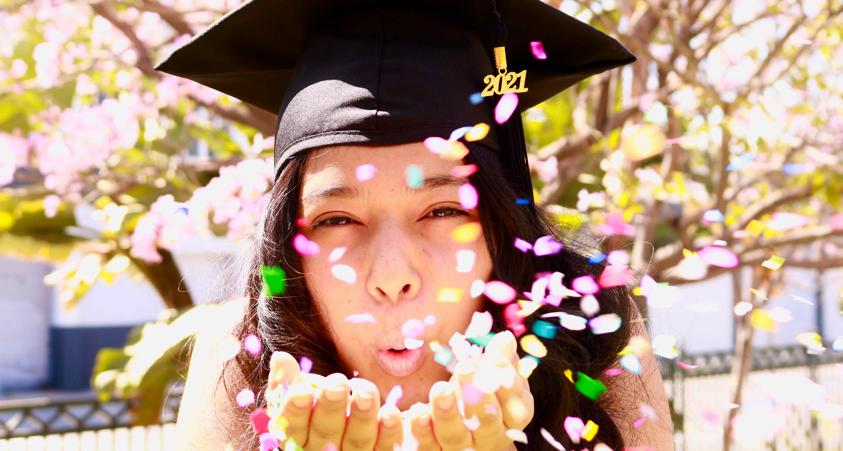 Hope Street graduate blowing confetti