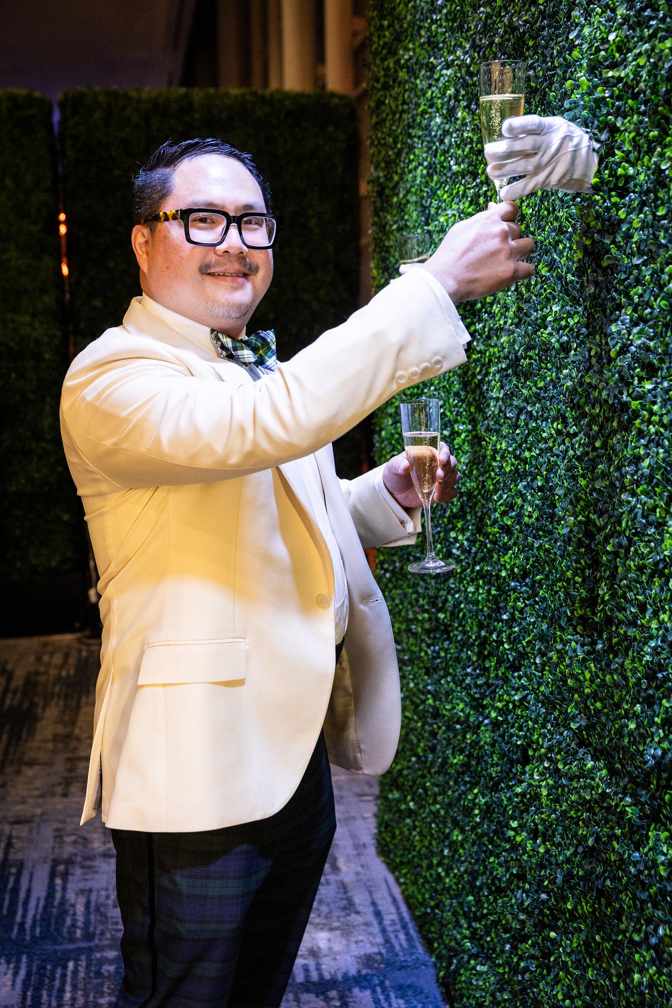 Dr. Rodney Cheng standing at the champagne wall