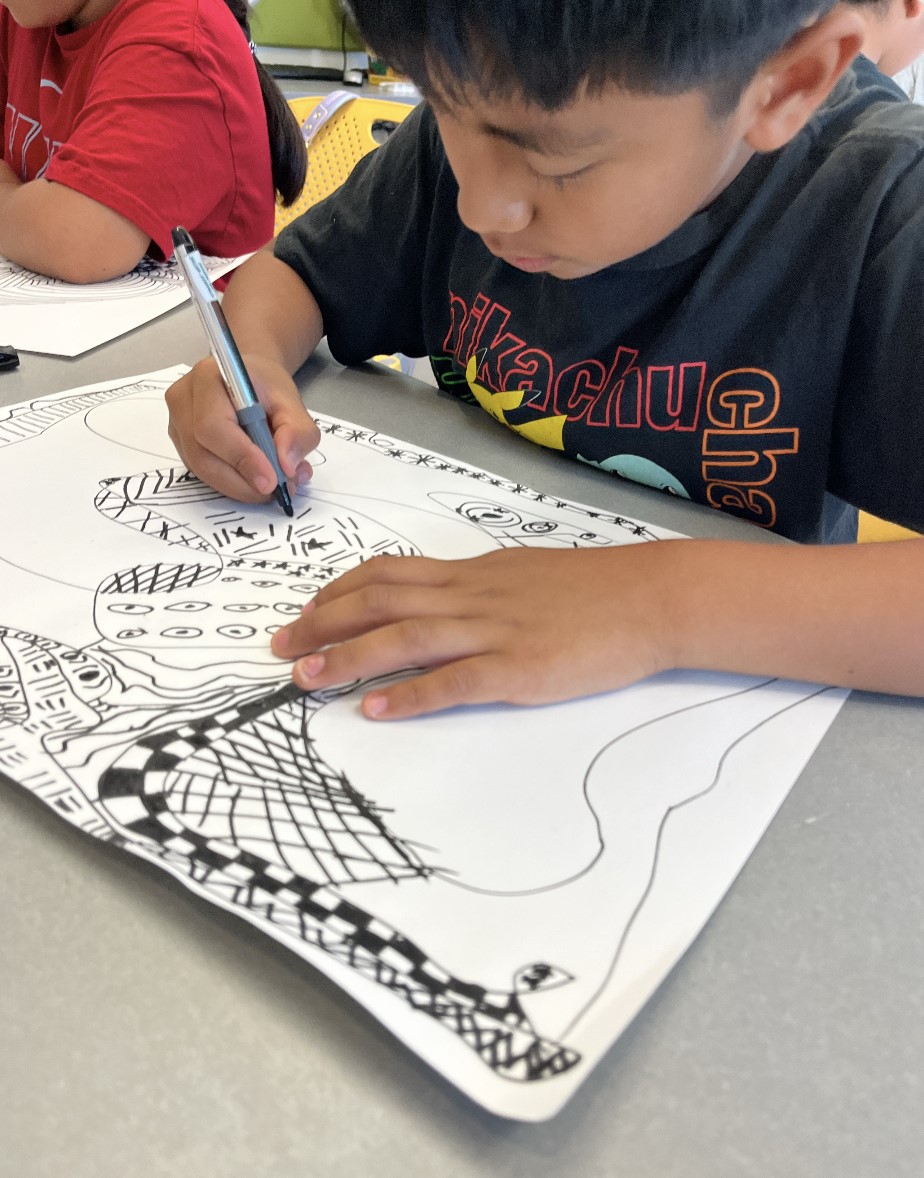 A student focuses on designing his sculpture that he will be making later in the summer