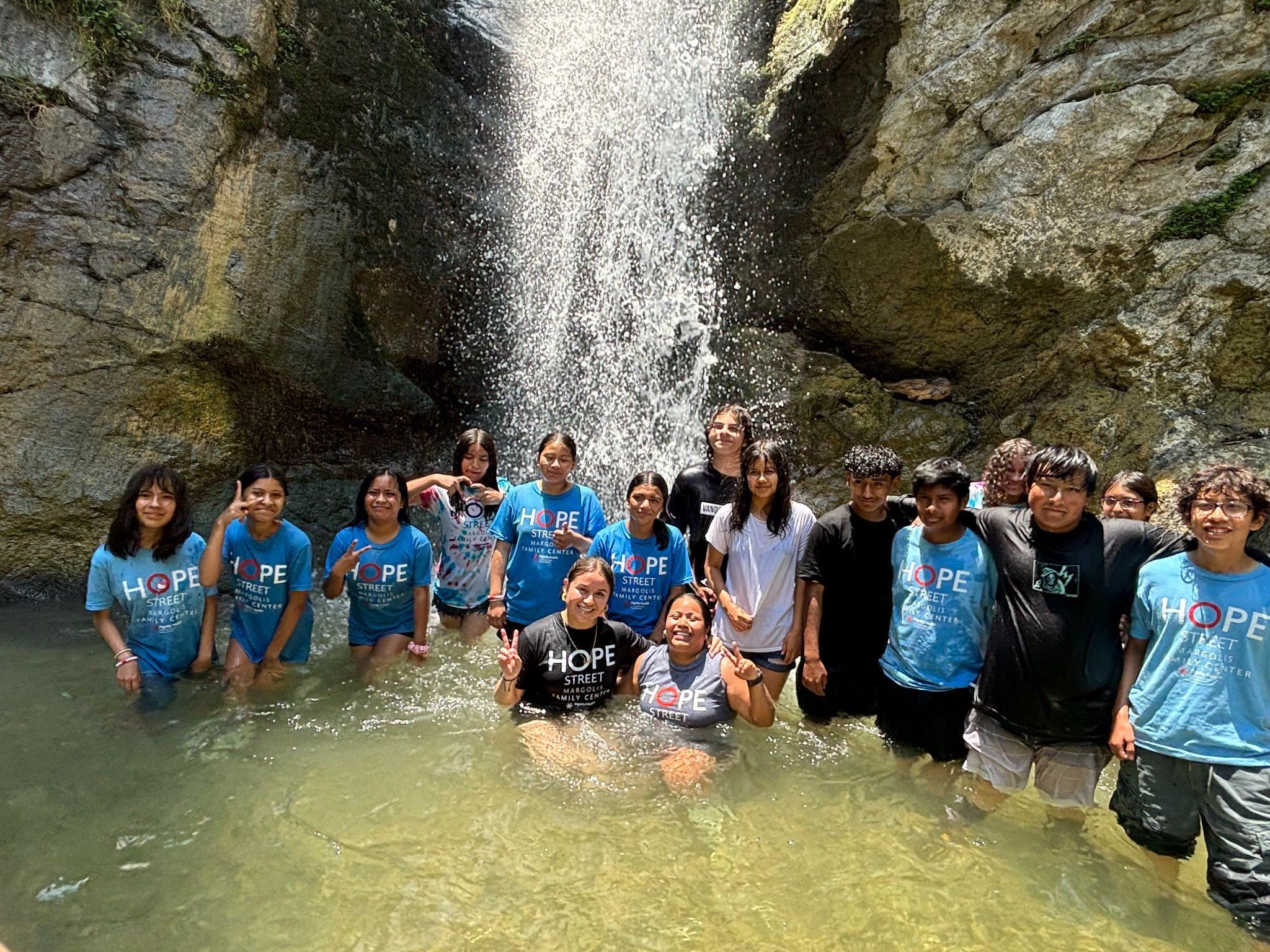 Students and staff pose for a picture under the Eaton Canyon waterfall